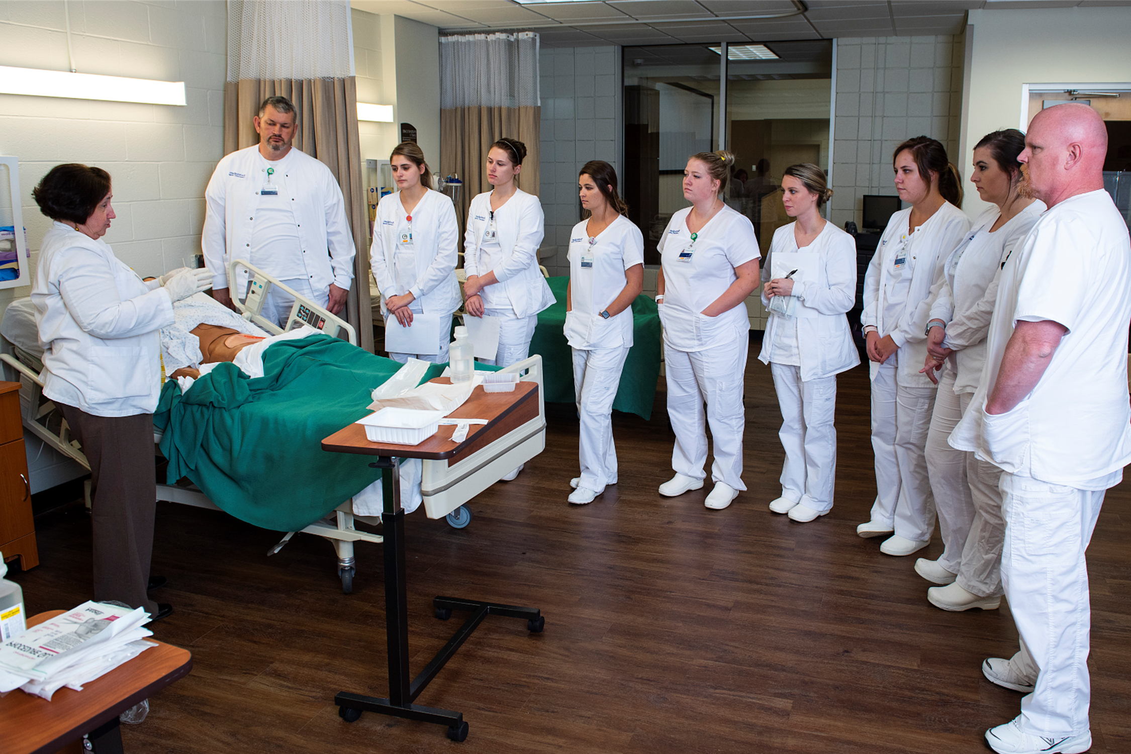 一群医学生正在接受一个站在人体模型旁边的老师的指导.